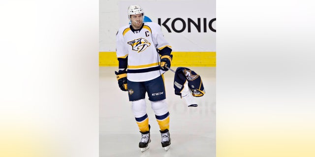 Nashville Predators Shea Weber (6) picks up a Predators jersey thrown on the ice by a fan during third period of an NHL hockey game in Edmonton, Alberta, Sunday, Jan. 26, 2014. (AP Photo/The Canadian Press, Jason Franson)