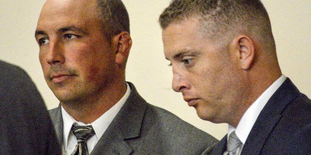 FILE - In this Aug. 18, 2015 file photo, former Albuquerque Police detective Keith Sandy, left, and Officer Dominique Perez speak with attorneys during a preliminary hearing in Albuquerque, N.M., on Tuesday, Aug. 18, 2015. They are expected to be arraigned Friday, Sept. 11, 2015 on second-degree murder charges in the on-duty shooting death of a homeless man who authorities say suffered from mental illness.(AP Photo/Russell Contreras, File)