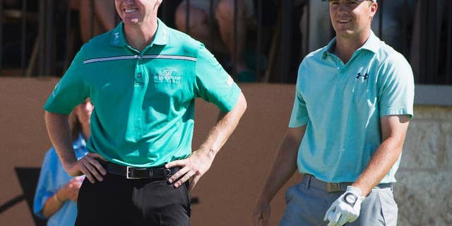 Jimmy Walker, left, and Jordan Spieth talk on the 16th tee during the final round of the Valero Texas Open golf tournament, Sunday, March 29, 2015, in San Antonio. Walker won the tournament. (AP Photo/Darren Abate)