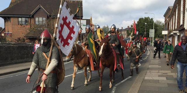 A group of historical re-enactors arrive in Battle, near Hastings, England, Friday Oct. 14, 2016, ending their 300-mile cross-country journey ready to mark the Battle of Hastings which was originaly fought 950-years ago.  The band of re-enactor enthusiasts set out from York, central England, on foot and horseback to simulate the journey by King Harold before the battle in 1066, when Normans under William the Conqueror defeated the English at the Battle of Hastings. (Tom Pugh / PA via AP)