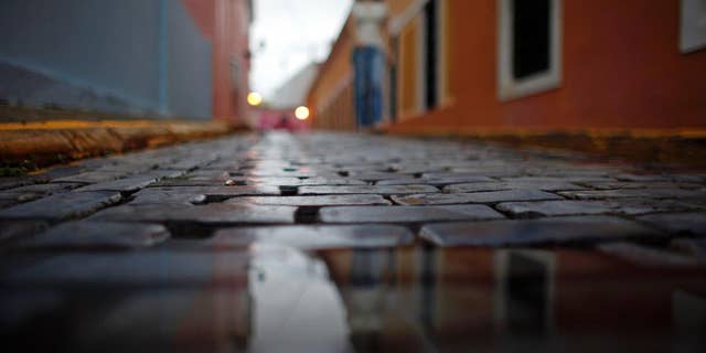 Wet cobblestones are seen on a street during a rainy day in Old San Juan, Puerto Rico, Tuesday, Nov. 4, 2014. Heavy rains caused by a cluster of storms in the northern Caribbean killed at least seven people in Haiti and caused major flooding on Tuesday in the Dominican Republic and Puerto Rico, authorities said. (AP Photo/Ricardo Arduengo)