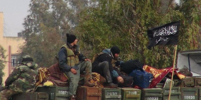 FILE - In this Friday, Jan. 11, 2013 file citizen journalism image provided by Edlib News Network, ENN, which has been authenticated based on its contents and other AP reporting, shows rebels from al-Qaida affiliated Jabhat al-Nusra, as they sit on a truck full of ammunition, at Taftanaz air base,  that was captured by the rebels, in Idlib province, northern Syria. An Islamist extremist group affiliated with al-Qaida, Jabhat al-Nusra has emerged as one of the most powerful rebel factions on the battlefield.(AP Photo/Edlib News Network, ENN, File)