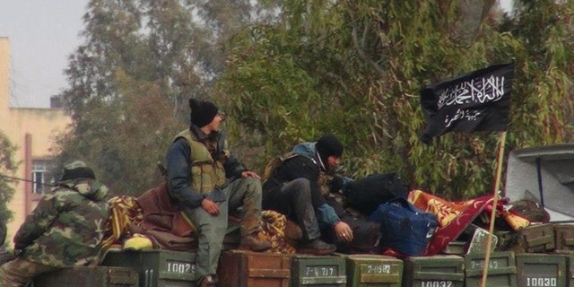 FILE - In this Friday, Jan. 11, 2013 file citizen journalism image provided by Edlib News Network, ENN, which has been authenticated based on its contents and other AP reporting, shows rebels from al-Qaida affiliated Jabhat al-Nusra, as they sit on a truck full of ammunition, at Taftanaz air base, that was captured by the rebels, in Idlib province, northern Syria. An Islamist extremist group affiliated with al-Qaida, Jabhat al-Nusra has emerged as one of the most powerful rebel factions on the battlefield.(AP Photo/Edlib News Network, ENN, File)