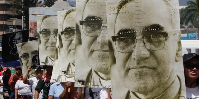 FILE - In this March 24, 2011 file photo, protesters carry portraits of slain Archbishop Oscar Arnulfo Romero on the 31st anniversary of his death in San Salvador, El Salvador. Perpetrators of human rights violations during El Salvador’s civil war such as Romero’s 1980 assassination could be prosecuted now that the country’s Supreme Court struck down an amnesty law protecting them, in a July 13, 2016 decision. Romero was fatally shot on orders by an official in El Salvador's U.S.-backed army as he celebrated Mass. (AP Photo/Luis Romero, File)
