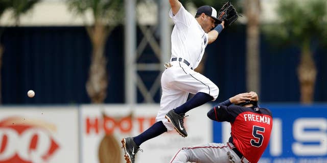 Detroit Tigers second baseman Ian Kinsler loses control of the ball as Atlanta Braves first baseman Freddie Freeman, right, slides under for a steal during the third inning of a spring exhibition baseball game in Lakeland, Fla., Tuesday, March 25, 2014. (AP Photo/Carlos Osorio)