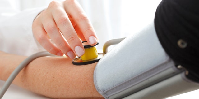 Close-up of Doctor/nurse checking blood pressure with stethoscope