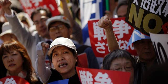 In this Thursday, May 14, 2015 photo, people stage an anti-war rally in protest against controversial bills intended to expand Japan’s defense role at home and internationally, pushed by Japanese Prime Minister Shinzo Abe, outside Abe's official residence in Tokyo. Abe's pledge to the U.S. to increase Japan's military contribution internationally is facing more questions about potential conflicts with the nation's pacifist Constitution. Opposition lawmakers demanded answers from key Cabinet members at a hearing Wednesday, June 10, 2015 after three prominent constitution experts — including one chosen by Abe's ruling party — unanimously told a parliamentary committee last week that legislation allowing Japanese troops to defend foreign militaries would violate the war-renouncing Article 9 of Japan's postwar constitution. (AP Photo/Eugene Hoshiko)