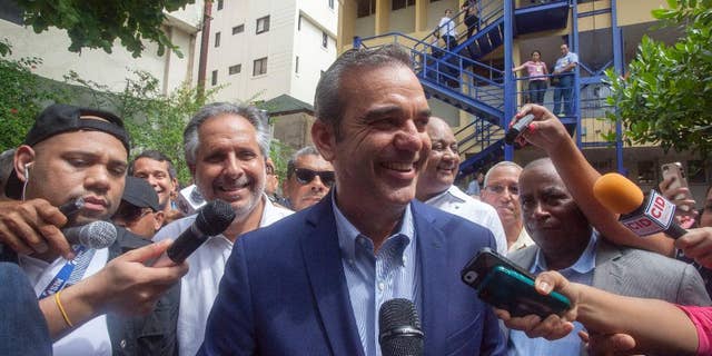 Luis Abinader, center, presidential candidate of the opposition Modern Revolutionary Party, speaks to the press after voting at the presidential, congressional and municipal elections in Santo Domingo, Dominican Republic, Sunday, May 15, 2016. Dominicans faced a dizzying array of choices Sunday in one of the most complex ballots in recent history, with eight candidates for president, all 222 members of Congress up for re-election and thousands of people vying for local offices around the country. Second from left behind Abinader is candidate for Mayor Alberto Atallah.(AP Photo/Tatiana Fernandez)