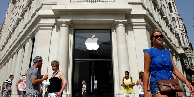 July 26: People walk past a closed shop, which will be opened and inaugurated as the largest Apple store in southern Europe at Passeig de Gracia, in Barcelona.