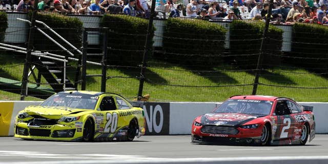 Driver Brad Keselowski (2) passes a damaged Matt Kenseth (20) during the NASCAR Sprint Cup series Pocono 400 auto race, Sunday, June 8, 2014, in Long Pond, Pa. (AP Photo/Mel Evans)