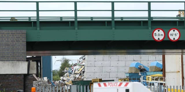 The scene at Hawkeswood Metal Recycling in the Nechells area of Birmingham where five men died after a wall collapsed, Thursday July 7, 2016. A sixth man was taken to a local hospital with leg injuries that were not said to be life-threatening. Police said the men were foreign nationals originally from Africa. (Chris Radburn/PA via AP)