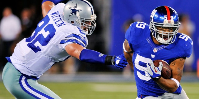 New York Giants linebacker Michael Boley (59) runs back an interception past Dallas Cowboys tight end Jason Witten (82) during the first half of an NFL football game, Wednesday, Sept. 5, 2012, in East Rutherford, N.J. (AP Photo/Bill Kostroun)