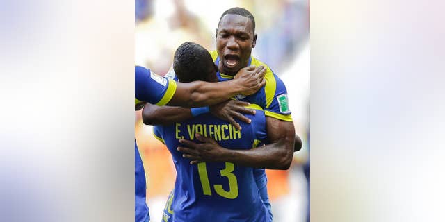 Ecuador's Walter Ayovi celebrates with opening goal scorer Enner Valencia (13) during the group E World Cup soccer match between Switzerland and Ecuador at the Estadio Nacional in Brasilia, Brazil, Sunday, June 15, 2014. (AP Photo/Michael Sohn)