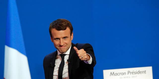 French centrist presidential candidate Emmanuel Macron thumbs up as he addresses his supporters at his election day headquarters in Paris , Sunday April 23, 2017. Macron and far-right populist Marine Le Pen advanced Sunday to a runoff in France's presidential election, remaking the country's political system and setting up a showdown over its participation in the European Union. (AP Photo/Christophe Ena)