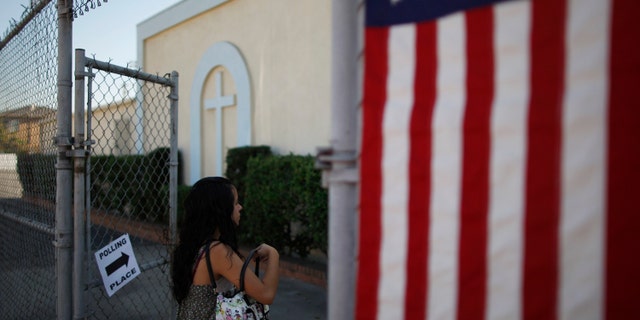 LOS ANGELES, CA - NOVEMBER 6: A woman enters a polling place in the heavily Latino East L.A. area during the U.S. presidential election on November 6, 2012 in Los Angeles, California. The election will decide whether Democrat Barack Obama serves a second term as president of the United States or is replaced by Republican rival, former Massachusetts Gov. Mitt Romney. (Photo by David McNew/Getty Images)
