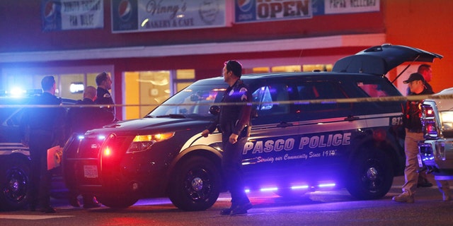 Police investigate the scene of an officer involved shooting Tuesday, Feb. 10. 2015 in Pasco, Wash.