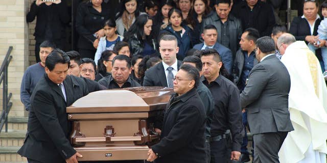 FILE - In this April 19, 2017 file photo, the casket of Justin Llivicura is carried from St. Joseph the Worker Church after Llivicura's funeral in East Patchogue, N.Y. Llivicura, 16, was one of four young men found slain in a suspected MS-13 gang killing in a park in Central Islip, N.Y., on April 12. The gang has been blamed for the deaths of nearly a dozen young people in blue-collar Brentwood and Central Islip since the school year began. (AP Photo/Frank Eltman, File)