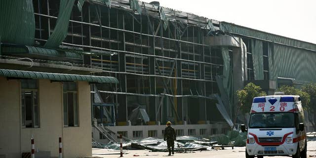In this photo released by China's Xinhua News Agency, an ambulance waits outside the site of a gas explosion at the Fuhua Engineering and Manufacturing Co. factory in Foshan city, south China's Guangdong Province Wednesday, Dec. 31, 2014. (AP Photo/Xinhua, Liang Xu) NO SALES