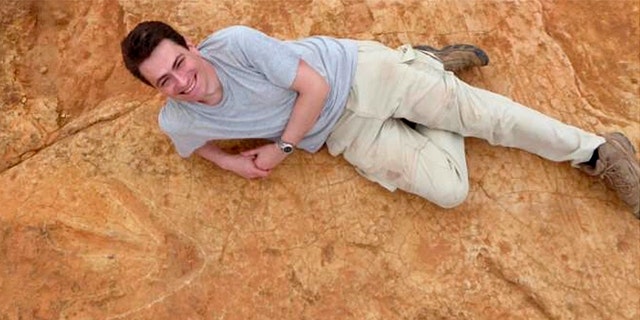 Fabien Knoll, Honorary Senior Research Fellow at the University of Manchester, lies next to the exceptionally large carnivorous dinosaur footprints found in Lesotho, Africa in this undated handout photo obtained by Reuters October 26, 2017. (Fabien Knoll/University of Manchester/Handout via REUTERS)