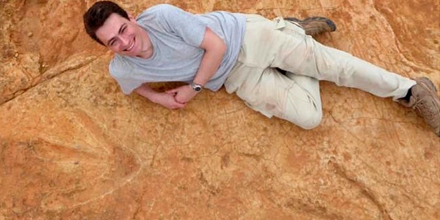Fabien Knoll, Honorary Senior Research Fellow at the University of Manchester, lies next to the exceptionally large carnivorous dinosaur footprints found in Lesotho, Africa in this undated handout photo obtained by Reuters October 26, 2017. (Fabien Knoll/University of Manchester/Handout via REUTERS)