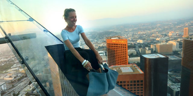 LOS ANGELES, CA - JUNE 25: A guest rides the SkySlide during the OUE Skyspace LA grand opening block party at OUE Skyspace LA on June 25, 2016 in Los Angeles, California. (Photo by Mark Davis/Getty Images for Ogilvy PR)