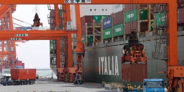 FILE - In this April 22, 2015 file photo, a cargo is loaded onto a truck at a port in Tokyo. Japan says its economy contracted at a 1.6 percent annual pace in the April-June quarter, as bad weather and slowing growth in China weakened demand. The gloomy preliminary growth data reported Monday, Aug. 17, 2015 was in line with expectations, though economists say that the longer term outlook is still positive. (AP Photo/Shizuo Kambayashi)