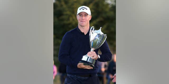 Sweden's Alex Noren celebrates with the trophy after winning The British Masters golf tournament at The Grove, Chandler's Cross, England, Sunday Oct. 16, 2016. (Steven Paston / PA via AP)
