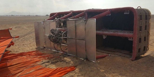 This Saturday, Jan. 14, 2017, released by Sharjah police, and made available today, shows a balloon that was carrying European and Asian tourists after it struck the ground as it flew over the desert near the small town of al-Madam, United Arab Emirates. Investigators in the UAE are looking into what caused a hot-air balloon to abruptly drop from the sky, injuring six tourists onboard. (Sharjah Police via AP)