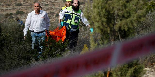 FILE - In this Dec. 19, 2010 file photo, Israeli rescue workers carry the body of U.S. tourist Kristine Luken after she was found in a wooded area near the village of Mata, outside Jerusalem. Two Palestinian men convicted in Israel of murdering Luken who was hiking near an Israeli archaeological site could face charges in the U.S. if they're ever released from an Israeli prison.  (AP Photo/Tara Todras-Whitehill, File)