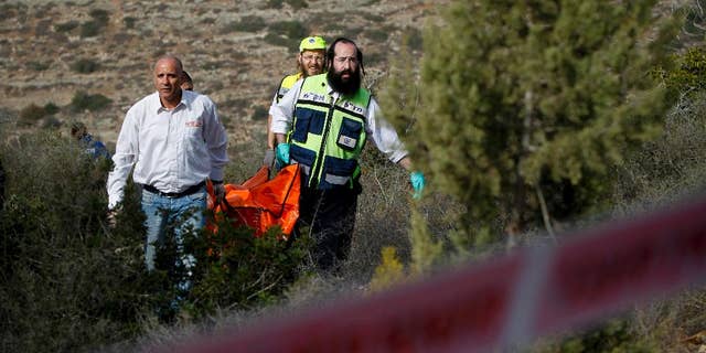 FILE - In this Dec. 19, 2010 file photo, Israeli rescue workers carry the body of U.S. tourist Kristine Luken after she was found in a wooded area near the village of Mata, outside Jerusalem. Two Palestinian men convicted in Israel of murdering Luken who was hiking near an Israeli archaeological site could face charges in the U.S. if they're ever released from an Israeli prison. (AP Photo/Tara Todras-Whitehill, File)