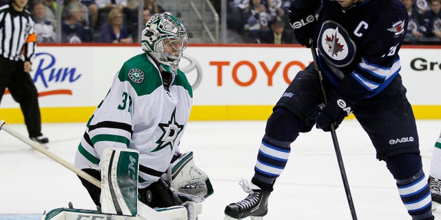 Winnipeg Jets' Andrew Ladd's (16) deflection is stopped by Dallas Stars' goaltender Kari Lehtonen (32) during second-period NHL hockey game action in Winnipeg, Manitoba, Friday, Oct. 11, 2013. (AP Photo/The Canadian Press, John Woods)