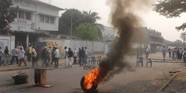Opposition supporters burn tires and barricade a road in protest after armed men set ablaze an independent television station that the government had previously tried to silence, in Kinshasa, Congo, Tuesday, Sept. 6, 2011.