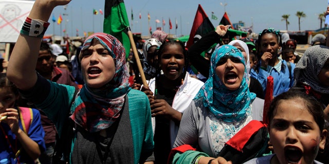 June 25: School students chant slogans against Muammar al-Qaddafi during a demonstration at the court square in the rebel-held capital Benghazi, Libya.