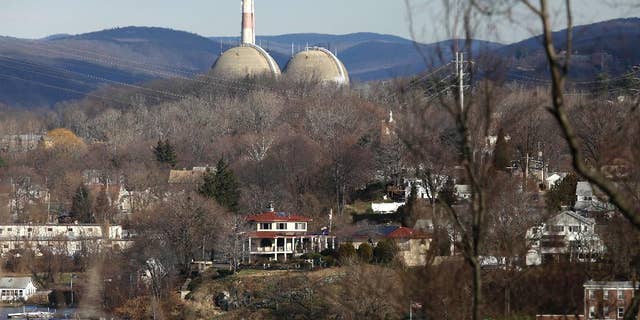 FILE - In this Wednesday, Dec. 16, 2009 photo, reactor containment domes of the Indian Point nuclear power plant in Buchanan, N.Y. rise above homes just north of the town of Verplanck, N.Y. as seen from the Stony Point Historic Site. The aging facility just north of New York City will close by April 2021 under a deal with Gov. Andrew Cuomo, who has long argued it should be shuttered to protect the millions of people living nearby. (AP Photo/Julie Jacobson)