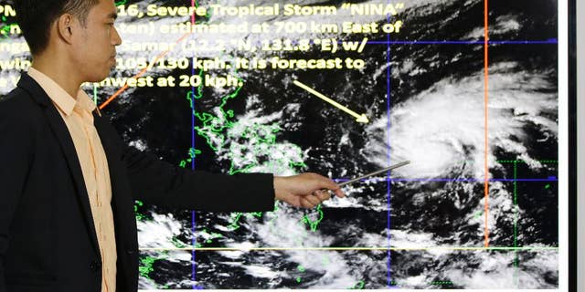 Weather specialist Benison Estareja shows the track of Tropical Storm Nock-Ten during a press conference in Quezon city, north of Manila, Philippines on Friday, Dec. 23, 2016. A severe tropical storm has gained strength as it moves closer to the Philippines and may intensify further into a typhoon, bringing moderate to heavy rains and blustery weather on Christmas Day, the biggest holiday in the predominantly Roman Catholic nation, weather forecasters said. (AP Photo/Aaron Favila)
