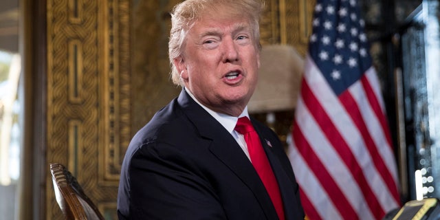 President Donald Trump turns to talk to the gathered media during a Christmas Eve video teleconference with members of the mIlitary at his Mar-a-Lago estate in Palm Beach, Fla., Sunday, Dec. 24, 2017.
