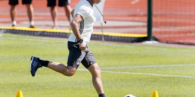 Coach Joachim Loew kicks the ball during the last training session of the German national football team at their base camp in Evian-Les-Bains, France, Wednesday, July 6, 2016. Germany will face France in a Euro 2016 semifinal soccer match in Marseille on Thursday, July 7, 2016 (AP Photo/Michael Probst)