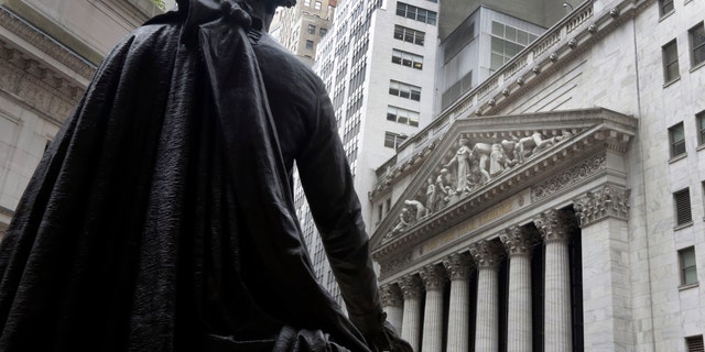 FILE - In this Oct. 2, 2014, file photo, the statue of George Washington on the steps of Federal Hall faces the facade of the New York Stock Exchange. U.S. employers added a vigorous 257,000 jobs in January, and wages jumped by the most in six years, evidence that the job market is accelerating closer to full health. The surprisingly robust report the government issued Friday, Feb. 6, 2015 also showed that hiring was far stronger in November and December than it had previously estimated. .(AP Photo/Richard Drew, File)