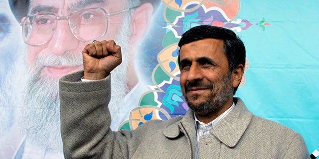 February 2011: Iranian President Mamoud Ahmadinejad, shown in this file photo pumping his fist, reportedly has been butting heads with Supreme Leader Ayatollah Ali Khamenei, in background.