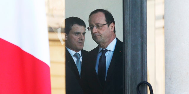 French President Francois Hollande, center right, and Interior Minister Manuel Valls leave after a meeting focused on the Malian situation, at the Elysee Palace in Paris, Monday, Jan. 14, 2013. French fighter jets bombed rebel targets in a major city in Mali’s north Sunday, pounding the airport as well as training camps, warehouses and buildings used by the al-Qaida-linked Islamists controlling the area, officials and residents said. (AP Photo/Christophe Ena)