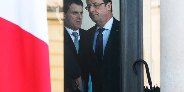 French President Francois Hollande, center right, and Interior Minister Manuel Valls leave after a meeting focused on the Malian situation, at the Elysee Palace in Paris, Monday, Jan. 14, 2013. French fighter jets bombed rebel targets in a major city in Mali’s north Sunday, pounding the airport as well as training camps, warehouses and buildings used by the al-Qaida-linked Islamists controlling the area, officials and residents said. (AP Photo/Christophe Ena)