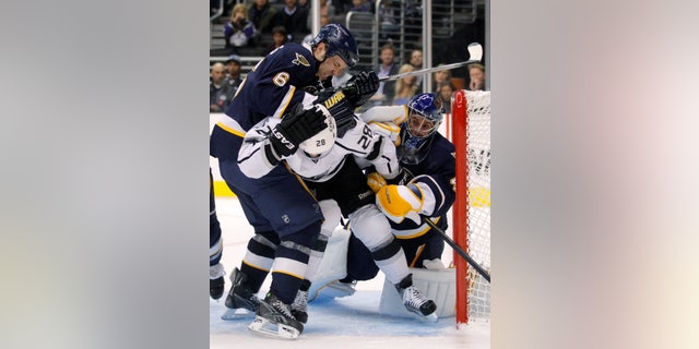 St. Louis Blues defenseman Kent Huskins, left, pushes Los Angeles Kings center Jarret Stoll in front of St. Louis Blues goalie Jaroslav Halak during the second period of an NHL hockey game in Los Angeles, Tuesday, Oct. 18, 2011. (AP Photo/Jae C. Hong)