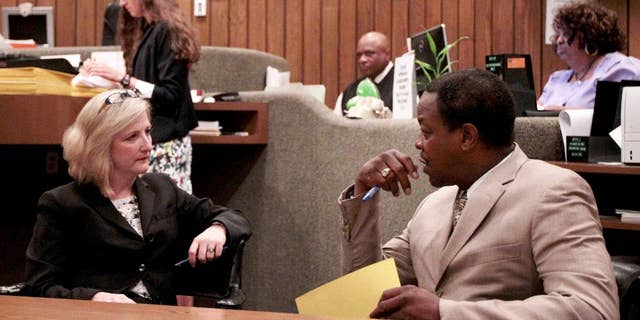 Prosecutors Alanda Dwyer, left, and Reginald Henderson talk before Judge Loyce Lambert Ryan's general session Court Division 15 is called to order as they await the video arraignment of Tremaine Wilbourn on charges of first degree murder for the death of Memphis Police officer Sean Bolton, Wednesday, Aug. 5, 2015, in Memphis. Wilbourn did not enter a plea on the charge of first-degree murder. (Mike Brown/The Commercial Appeal via AP)