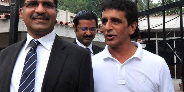 Pakistani umpire Asad Rauf (R) leaves with his legal adviser Syed Ali Zafar after a press conference in Lahore on September 27, 2013.