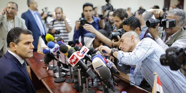 Journalists surround Egypt's Deputy Public Prosecutor Mustafa Suleiman, who headed an Egyptian delegation that was in Rome last week, as he prepares to speak during a press conference on slain Italian graduate student Giulio Regeni, at the prosecutor general's office, in Cairo, Egypt, Saturday, April 9, 2016. (AP Photo/Amr Nabil)