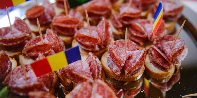 FILE- In this Friday, March. 18, 2016 file picture a platter of Sibiu salami, the local king of the smoked sausages, is presented to the media during a press conference, in Bucharest, Romania. Romanian lawmakers have adopted, Wednesday, June 8, 2016, legislation obliging supermarkets to sell at least 51 percent home-produced meat, fruit, eggs and vegetables in a move to support farmers.(AP Photo/Andreea Alexandru, File) ROMANIA OUT