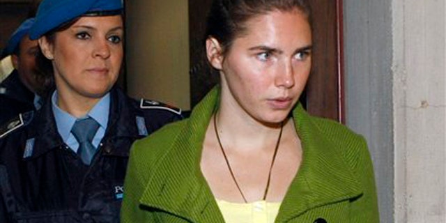 Dec. 4: Amanda Knox is accompanied by a penitentiary police officer prior to a final hearing at the court in Perugia, Italy. Knox was found guilty of murdering her British roommate Meredith Kercher. (AP photo)