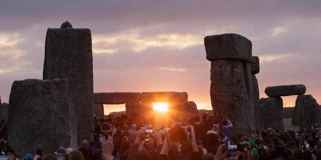 FILE - In this June 21, 2015, file photo, the sun rises as thousands of revelers gathered at the ancient stone circle Stonehenge to celebrate the Summer Solstice, the longest day of the year, near Salisbury, England. The solstice occurs Monday, June 21, 2016, at 6:34 p.m. on the U.S. East Coast. (AP Photo/Tim Ireland, File)