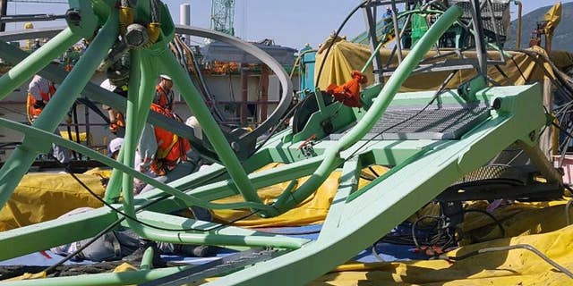 A part of a collapsed crane is seen fallen on the ground at Samsung Heavy Industries' shipyard on Geoje Island, South Korea, Monday, May 1, 2017. Samsung Heavy Industries say a crane has collapsed at its shipyard in South Korea, killing several workers and injuring many more. (Lee Jung-hoon/Yonhap via AP)