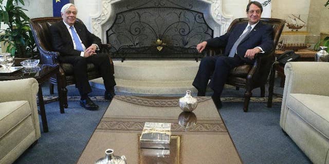 Cypriot President Nikos Anastasiades, right, and Greek President Prokopis Pavlopoulos pose for photographers prior to their meeting at the presidential palace in Nicosia in the eastern Mediterranean island of Cyprus, Thursday, Jan. 19, 2017. Pavlopoulos is in Cyprus for a one-day visit. (AP Photo/Petros Karadjias)